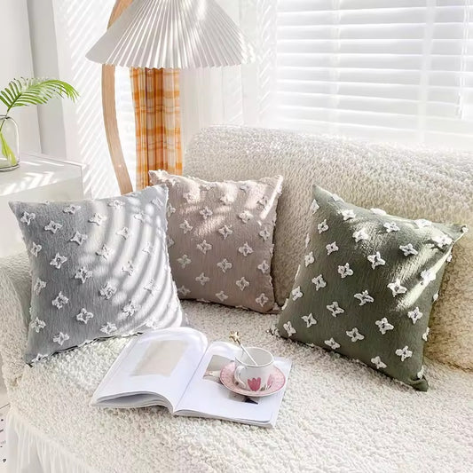 Funda de cojín verde con figuras en relieve.