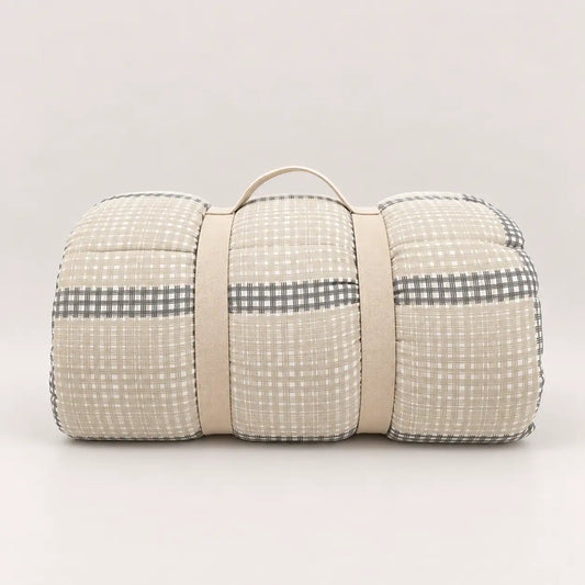 Piumone da mezza stagione con pratica maniglia per riporlo, con lato principale a quadri nei toni del beige e grigio.