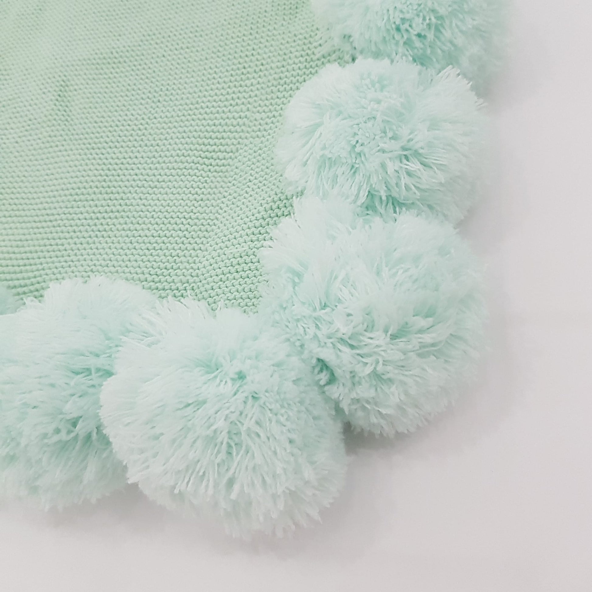 Funda de cojín tejido con pompones 45cm x 45cm. Color verde menta. - Oma Home