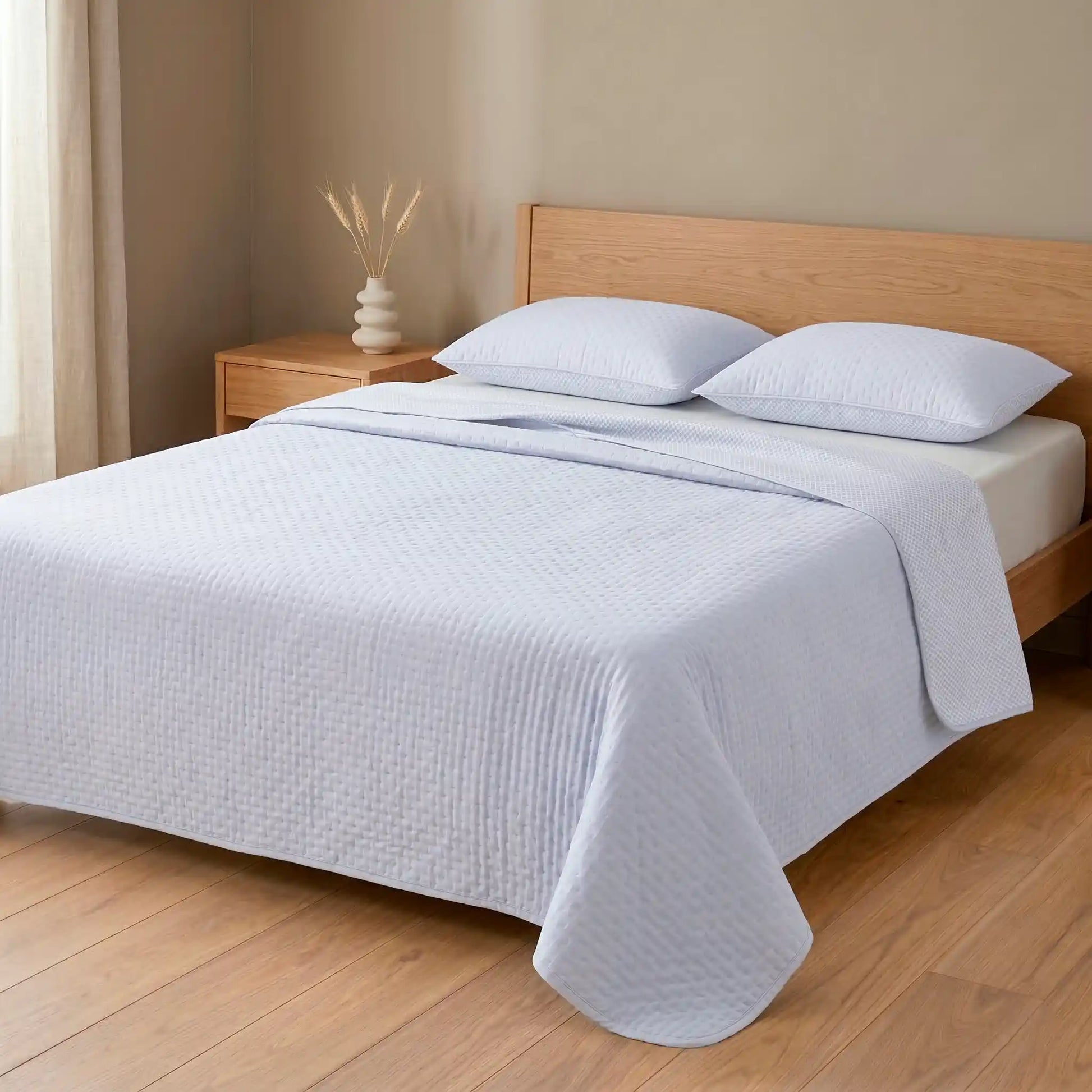 Cama de matrimonio vestida con colcha bouti de verano en tono azul lavanda relajante