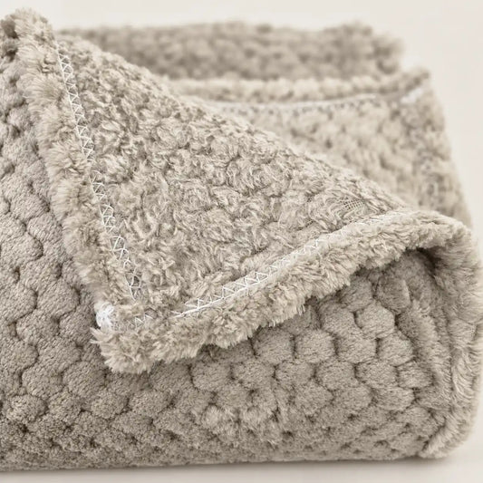 Primer plano del remate de la costura y el borde de la manta polar fina en color beige de Oma Home.
