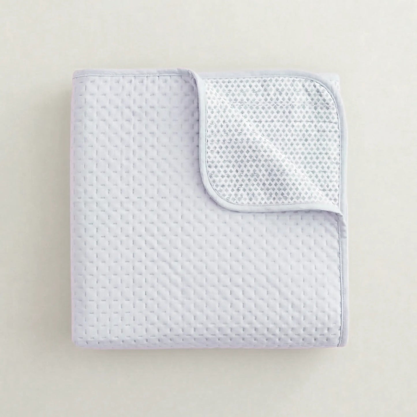 Primer plano del acolchado fino y costuras de la colcha azul lavanda