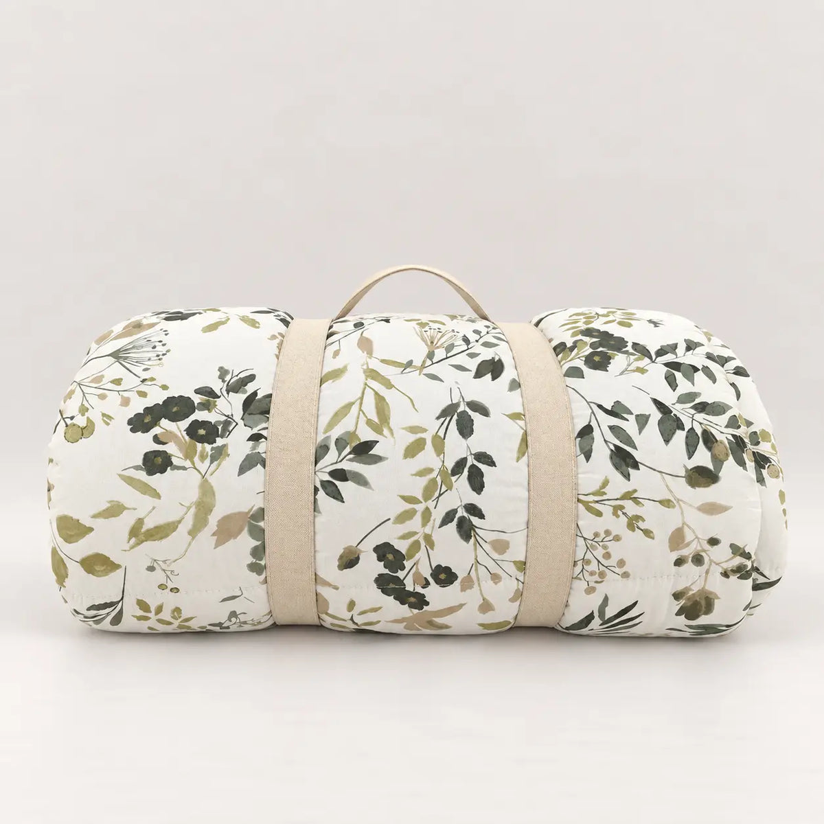 Green leaf duvet rolled up with a practical handle for easy wardrobe storage.