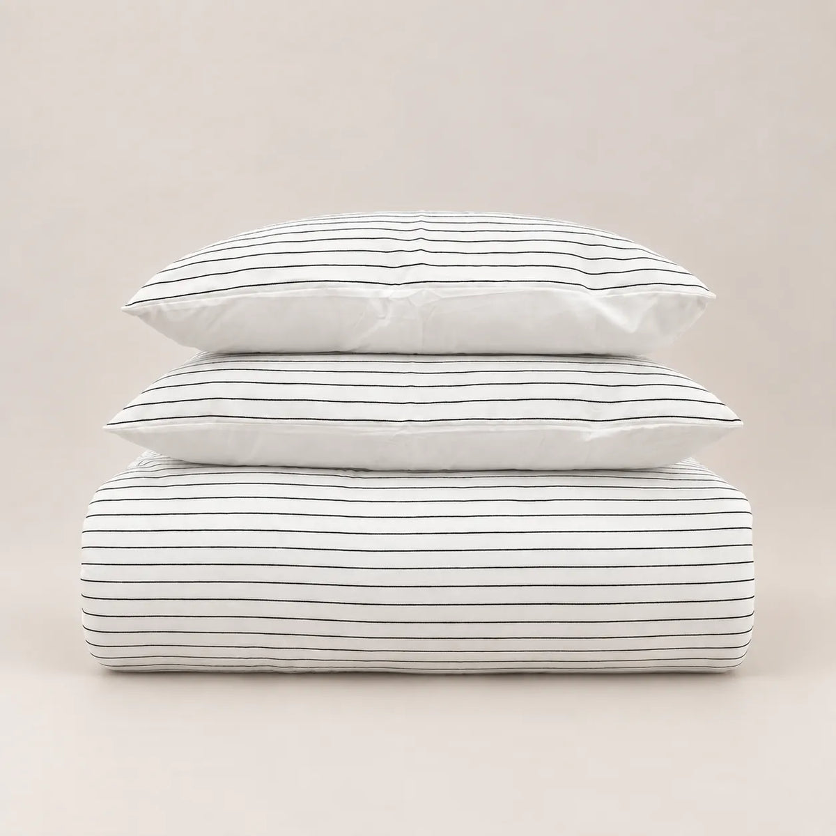 Winter duvet with a fine jacquard stripe design, neatly folded with two matching pillowcases.
