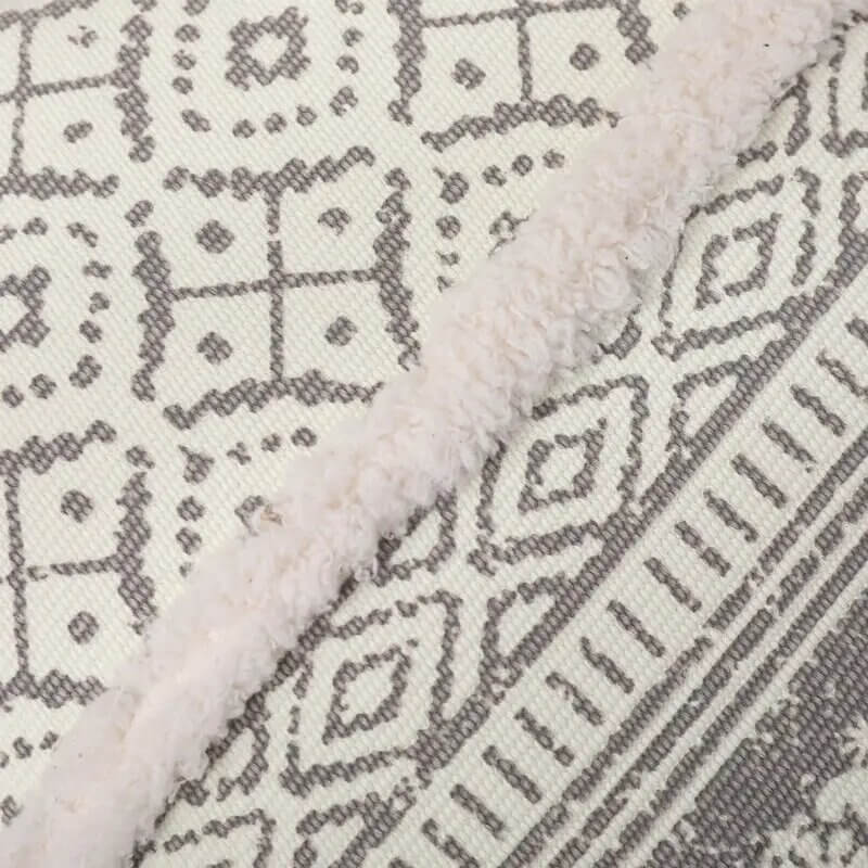 Funda de cojín boho étnico en blanco y gris claro con flecos.