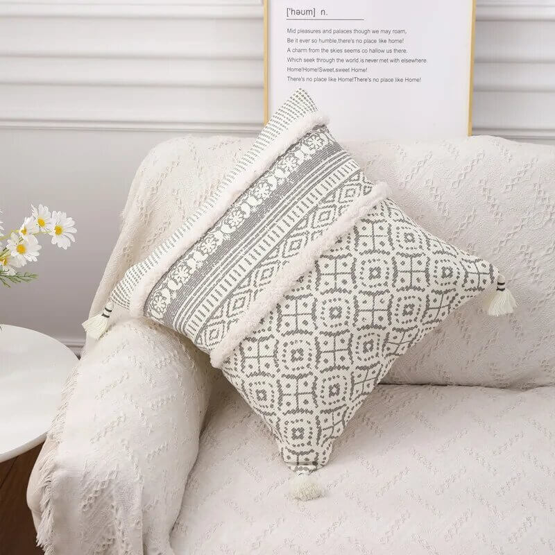 Funda de cojín boho étnico en blanco y gris claro con flecos.